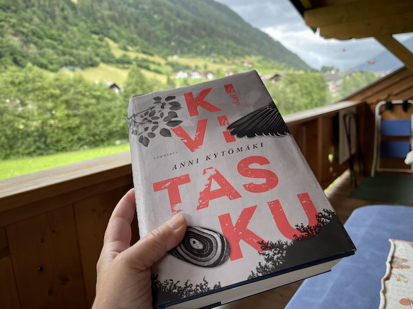 Kesäkirjat 2024. Kuvassa Anni Kytömäen kirja Kivitasku. Taustalla vuorimaisema.
