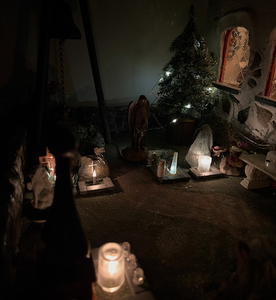 Miniatyyrihautausmaa jossa näkyvillä hautoja ja niillä loistaa kynttilät.