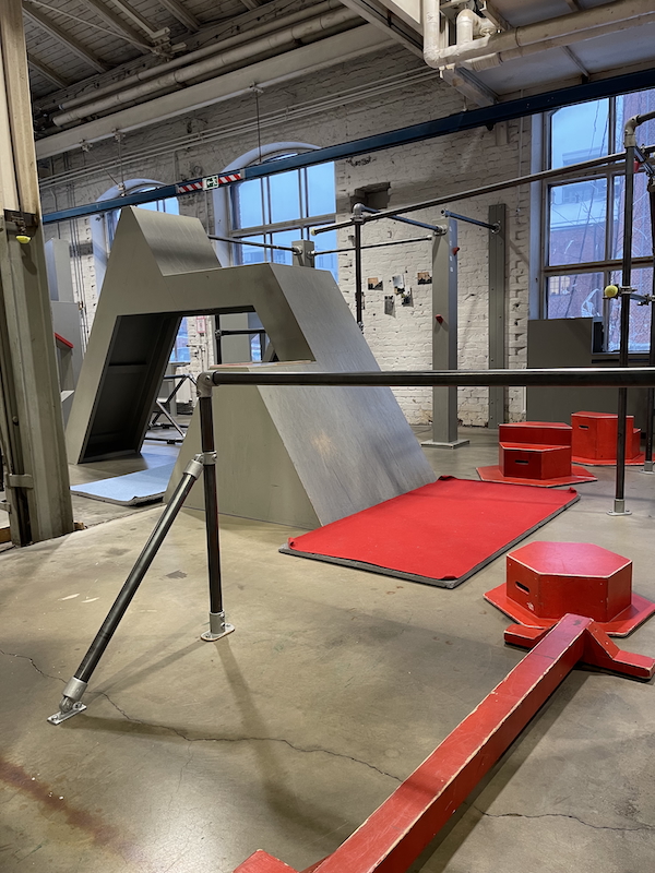 Tammikuun pienet suuret hetket. Kuvassa näkymä Helsingin Parkour Akatemian Vallilan toimitilasta. Punaisia ja harmaita esteitä sekä tankoja.