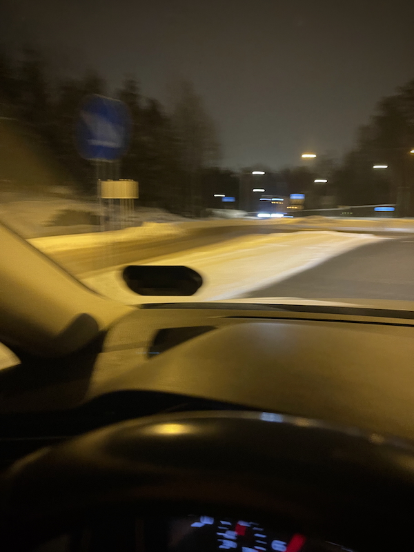 Tammikuun pieniä suuria hetkiä. Pimeä katuvalojen valaisema tie. Kuva on epätarkka.