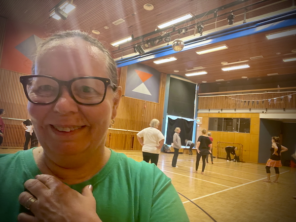 Tanssi tukee muistia ja tasapainoa. Kuvassa nainen ja taustalla näkyy liikuntasali jossa ihmisiä.