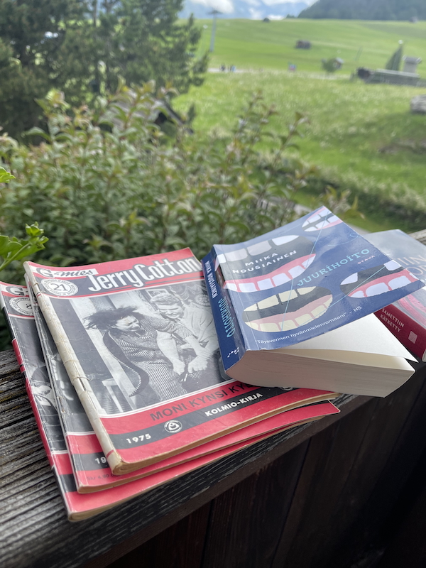 Kesäkirjat 2025. Kuvassa Jerry Cottonit ja Juurihoito-kirja parvelleen kaiteella.