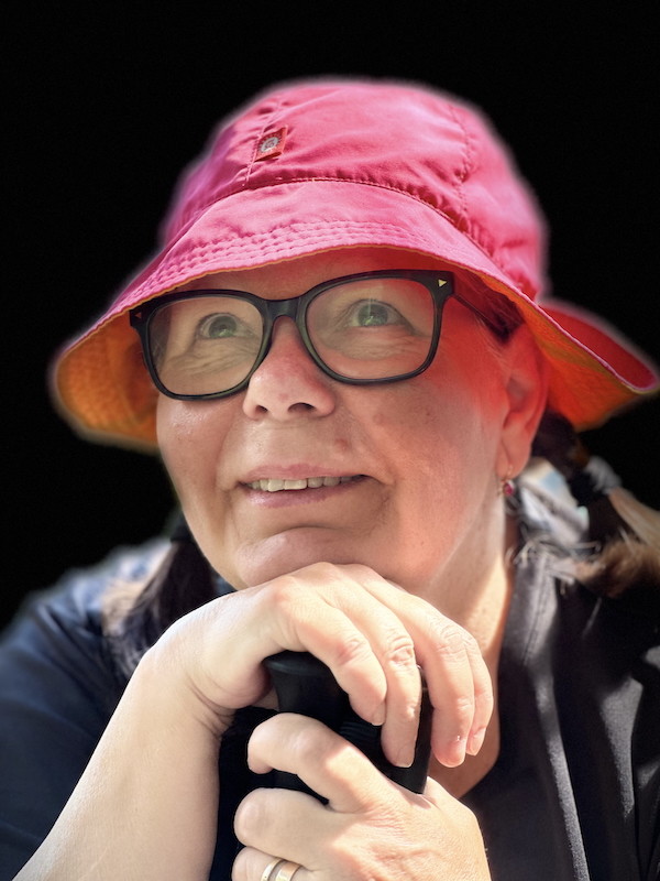 Mikä tekee sinusta sinut. Kuvassa nainen joka nojaa kävelysauvoihin ja katselee ylöspäin